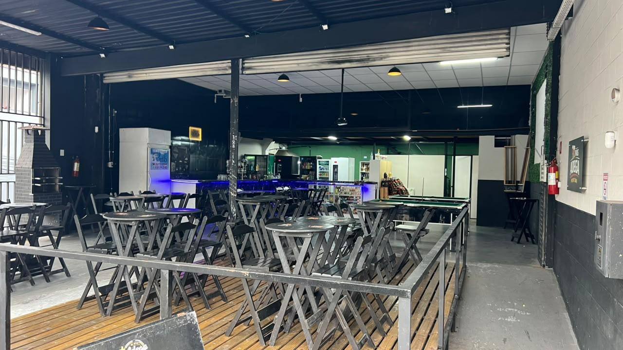 Salão da Mais Adega com mesas, balcão iluminado e mesa de sinuca